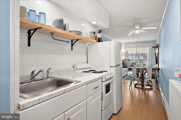 a kitchen with appliances cabinets and wooden floor
