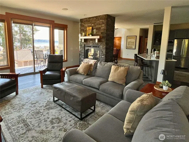 a living room with furniture ceiling fan and a large window