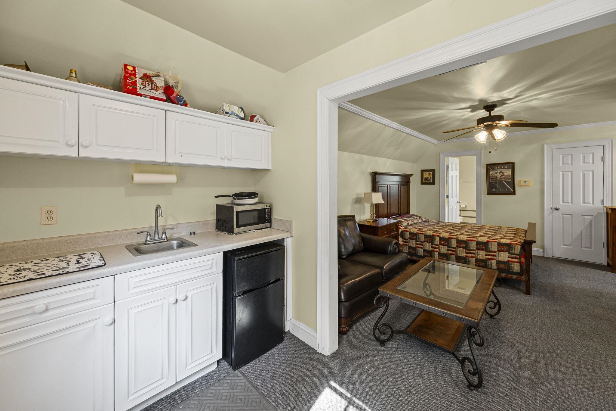 450 Cherry Road Eads, TN 38028 - Photo 22 of 24 Kitchen featuring white cabinetry, freestanding refrigerator, light countertops, lofted ceiling, and stainless steel microwave