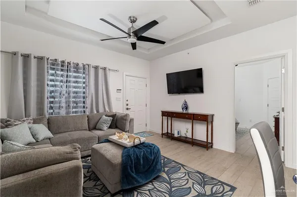 a living room with furniture a ceiling fan and a window