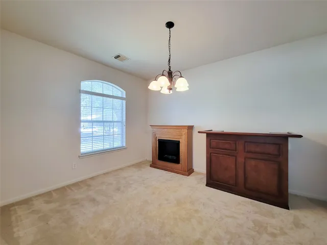 a view of a livingroom with a fireplace cabinet and windows
