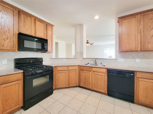 a kitchen with granite countertop cabinets stainless steel appliances and a sink