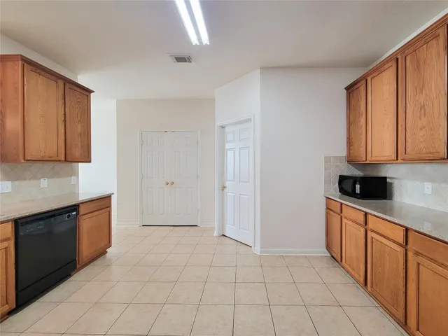 a large kitchen with stainless steel appliances granite countertop a stove a sink and a refrigerator