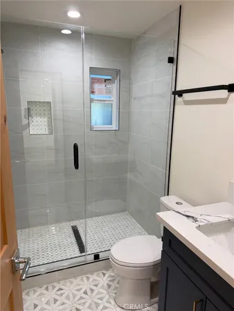 a bathroom with a granite countertop sink toilet and shower