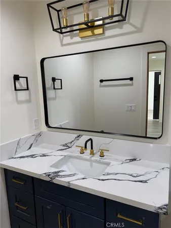 a bathroom with a granite countertop sink and a mirror