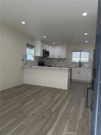 a view of a kitchen with a sink microwave and cabinets