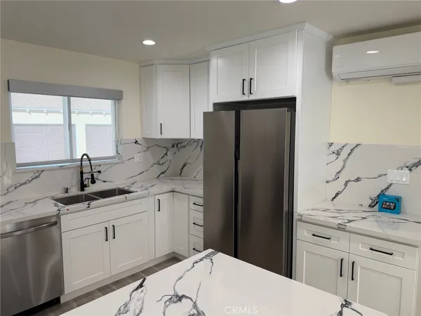 a kitchen with granite countertop a sink stove and refrigerator