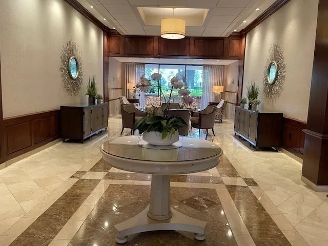 a room with two sinks a desk and a large window