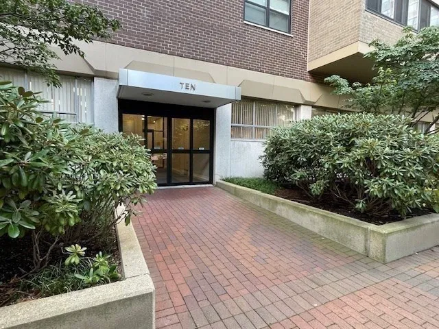 a view of a tall house with a yard and large trees