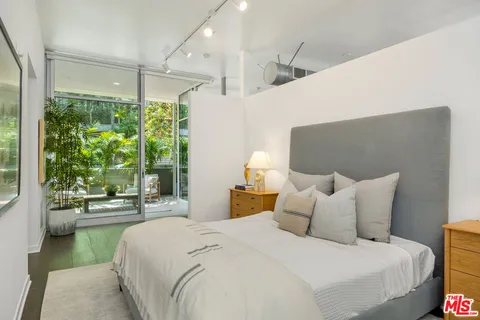 a bedroom with a bed and a large window