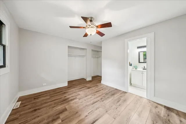 a view of empty room with wooden floor and ceiling fan