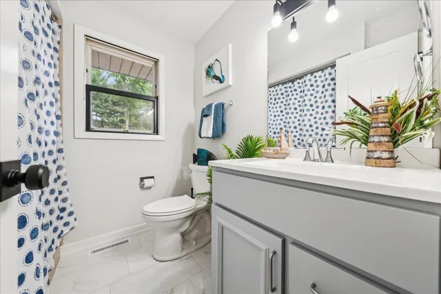 a bathroom with a sink a toilet and a shower curtain