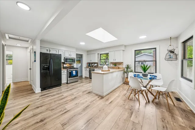 a view of a kitchen with furniture and wooden floor