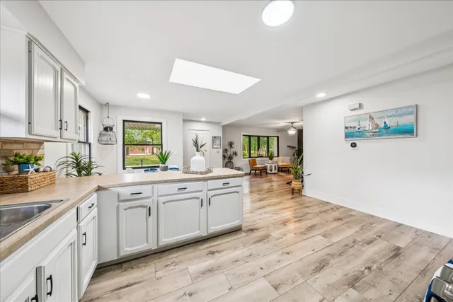 a large kitchen with kitchen island a sink stainless steel appliances and cabinets