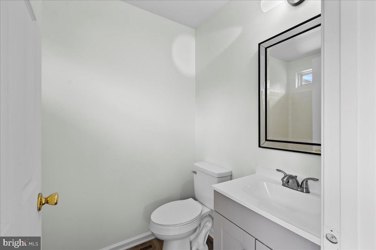 77 Wicklow Road Bear, DE 19701 - Photo 33 of 54 a bathroom with a toilet sink vanity and mirror