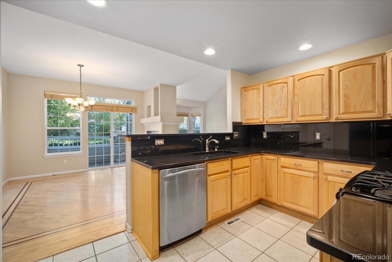 6115 Trailhead Road Highlands Ranch, CO 80130 - Photo 17 of 40 a kitchen with stainless steel appliances granite countertop a stove a sink and a microwave