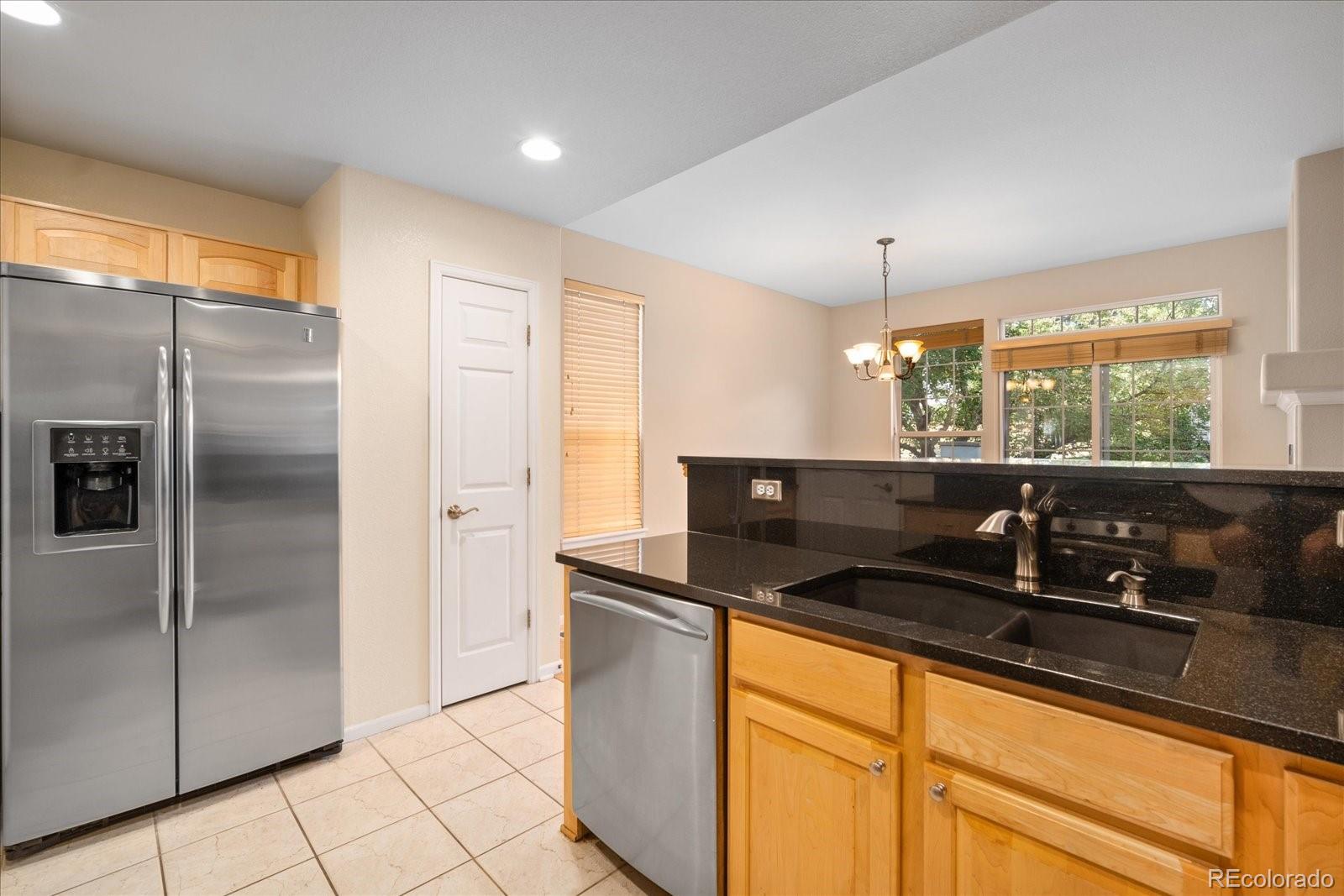 6115 Trailhead Road Highlands Ranch, CO 80130 - Photo 18 of 40 a kitchen with stainless steel appliances granite countertop a sink and a refrigerator