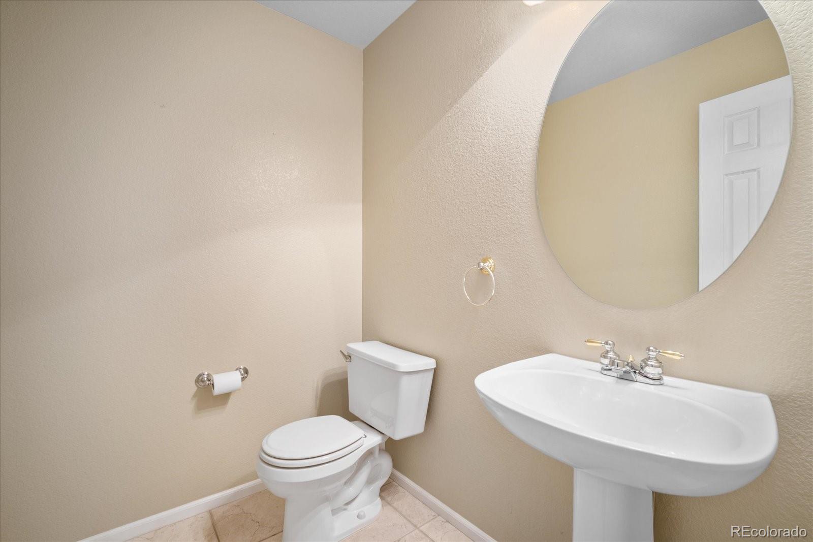 6115 Trailhead Road Highlands Ranch, CO 80130 - Photo 21 of 40 a bathroom with a sink a toilet and mirror