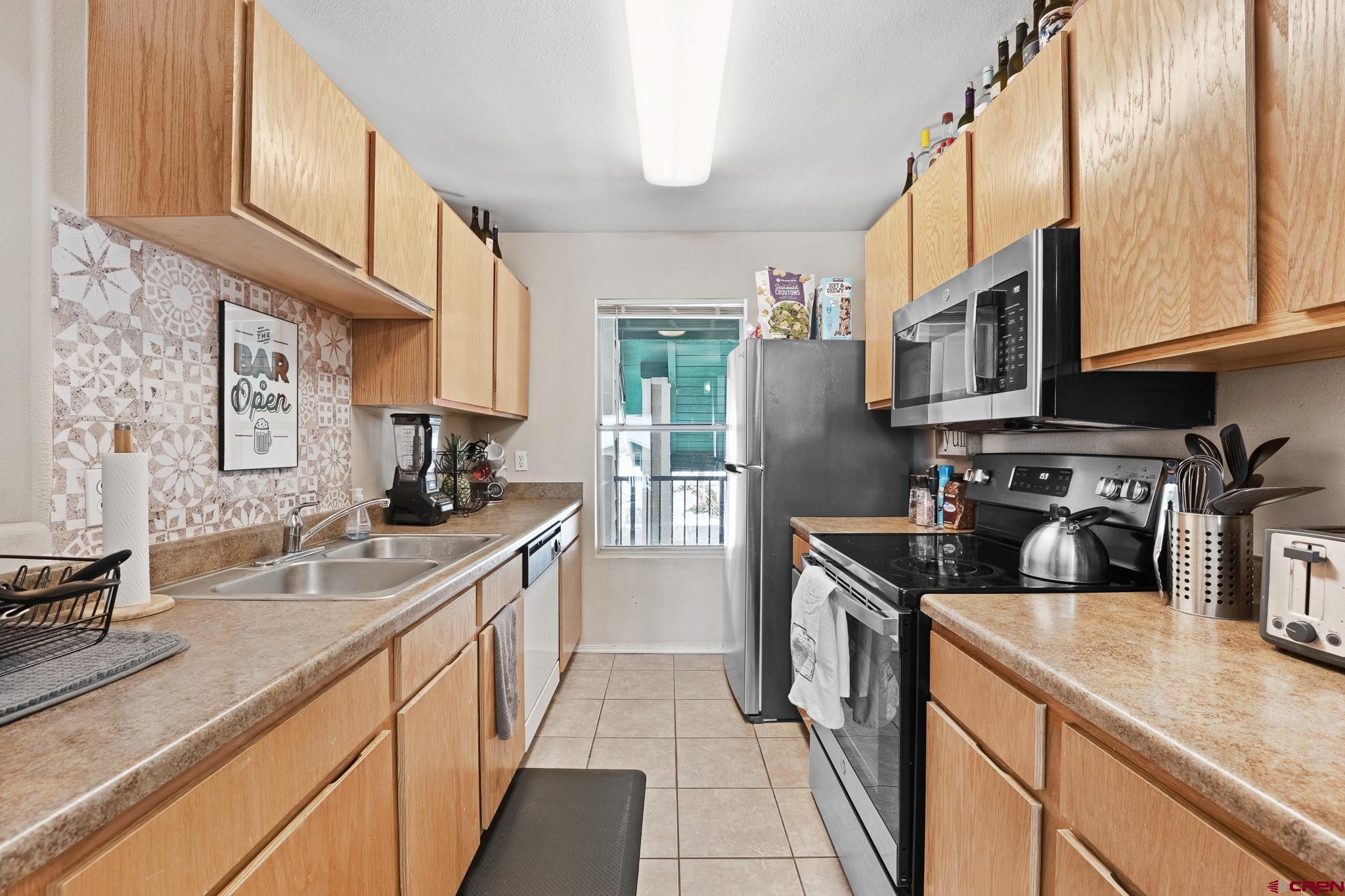 1100 Goeglein Gulch Road, Unit 206 Durango, CO 81301 - Photo 7 of 29 a kitchen with stainless steel appliances granite countertop a sink stove and refrigerator