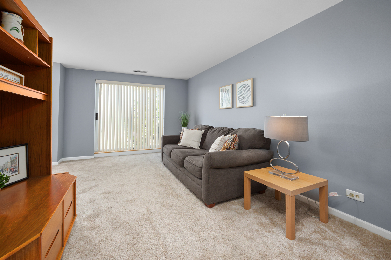 815 Leicester Road, Unit 219 Elk Grove Village, IL 60007 - Photo 12 of 26 a living room with furniture a flat screen tv and a window