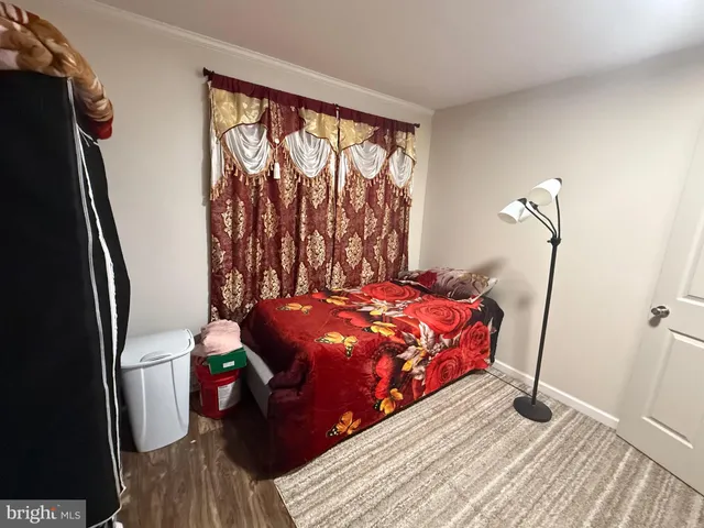 a bedroom with a bed toilet and a large window