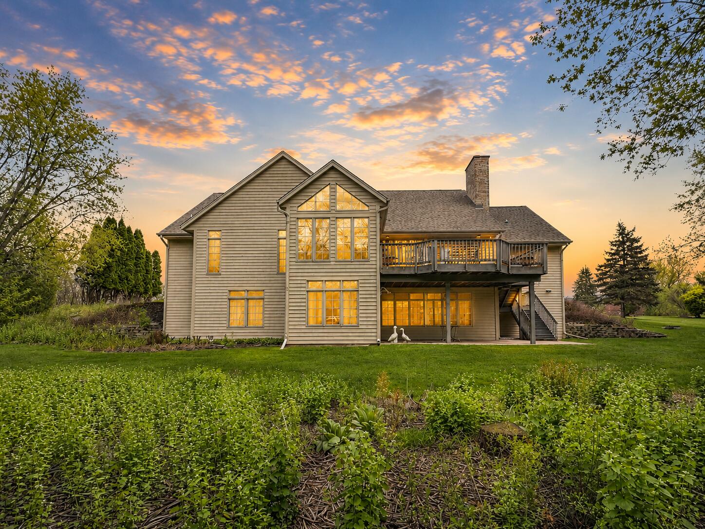 W291-s5245 Ridgefield Road Waukesha, WI 53189 - Photo 5 of 44 Impressive rear elevation featuring expansive windows, a composite deck, and covered patio overlooking the private backyard. (Enhanced Photo)