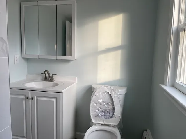 a bathroom with a toilet a sink and a mirror
