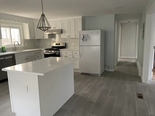 a kitchen that has a sink a window in it and a dishwasher with wooden floor