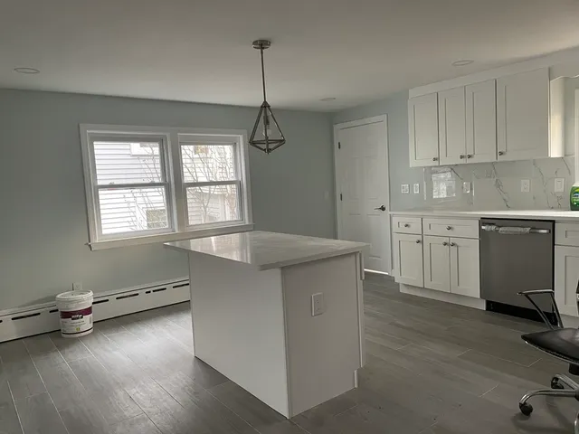 a kitchen with a sink a counter top space stainless steel appliances and cabinets