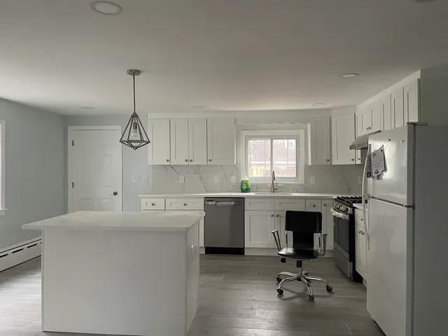 a kitchen with white cabinets and white appliances