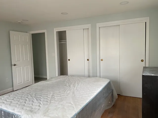 a bed sitting in a bedroom next to a window