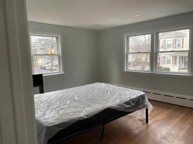 a bathroom with a granite countertop sink a toilet and a window
