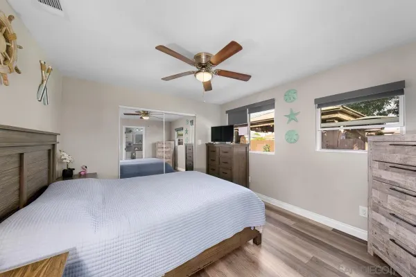 a bedroom with a large bed a flat tv screen and dresser