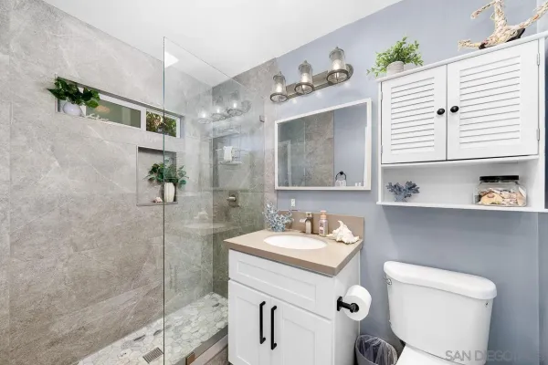 a bathroom with a sink a toilet and shower