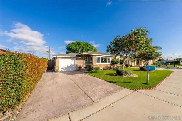 a front view of a house with a yard and trees