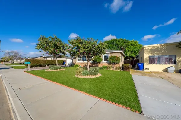 a view of a house with backyard and a tree