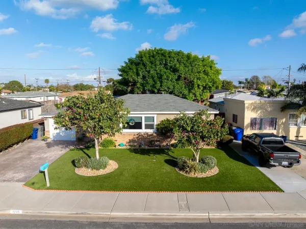 a front view of a house with a yard garden and outdoor seating