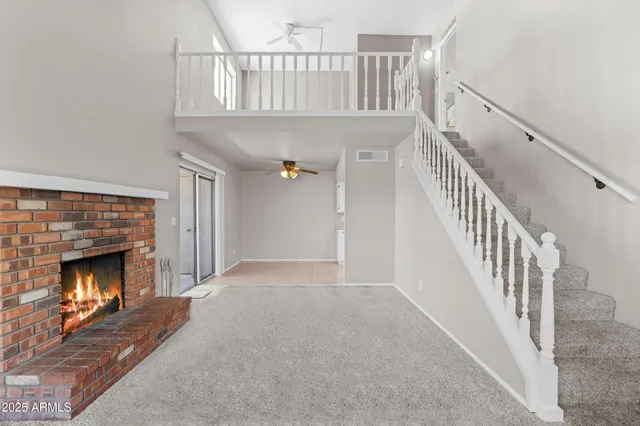 a view of an empty room wooden floor fireplace and a window