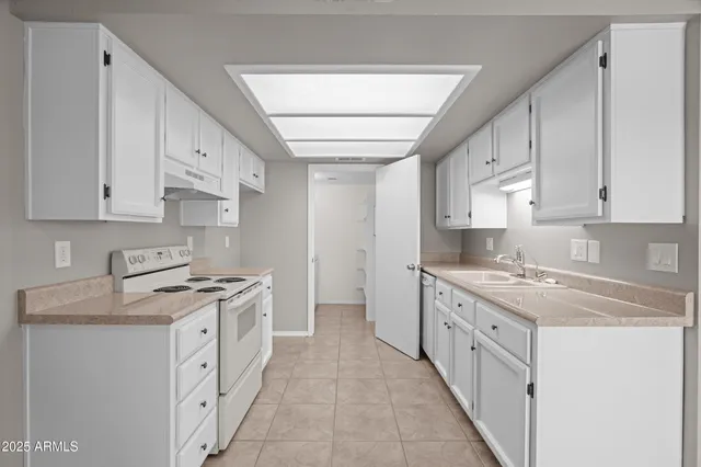 a kitchen with granite countertop a sink stove and cabinets