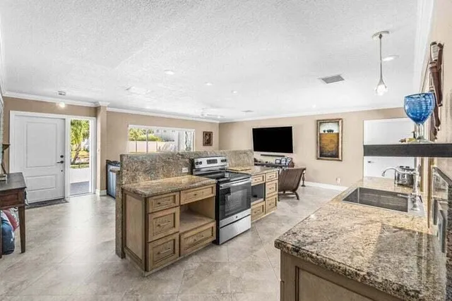 a kitchen with stainless steel appliances granite countertop a stove and a sink