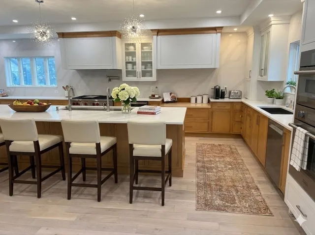 a large kitchen with stainless steel appliances granite countertop a lot of counter space and a sink