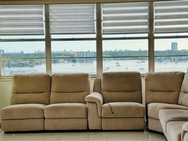 a large kitchen with kitchen island white cabinets and stainless steel appliances