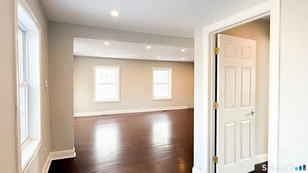 a view of an empty room with wooden floor