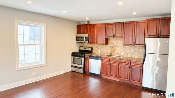 a kitchen with granite countertop a stove sink and cabinets