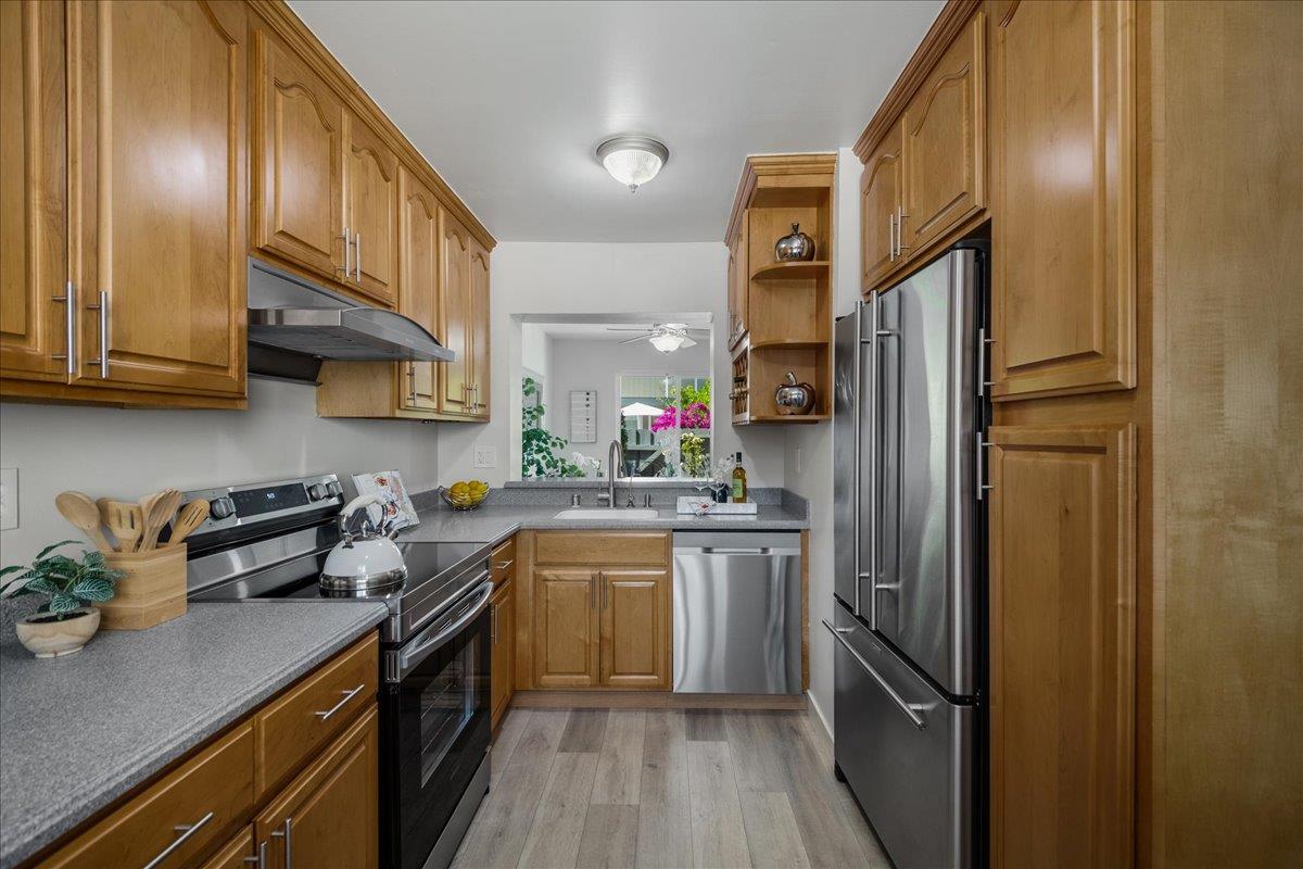 4790 Raspberry Place San Jose, CA 95129 - Photo 11 of 45 a kitchen with stainless steel appliances granite countertop a refrigerator a sink dishwasher a stove and white cabinets with wooden floor