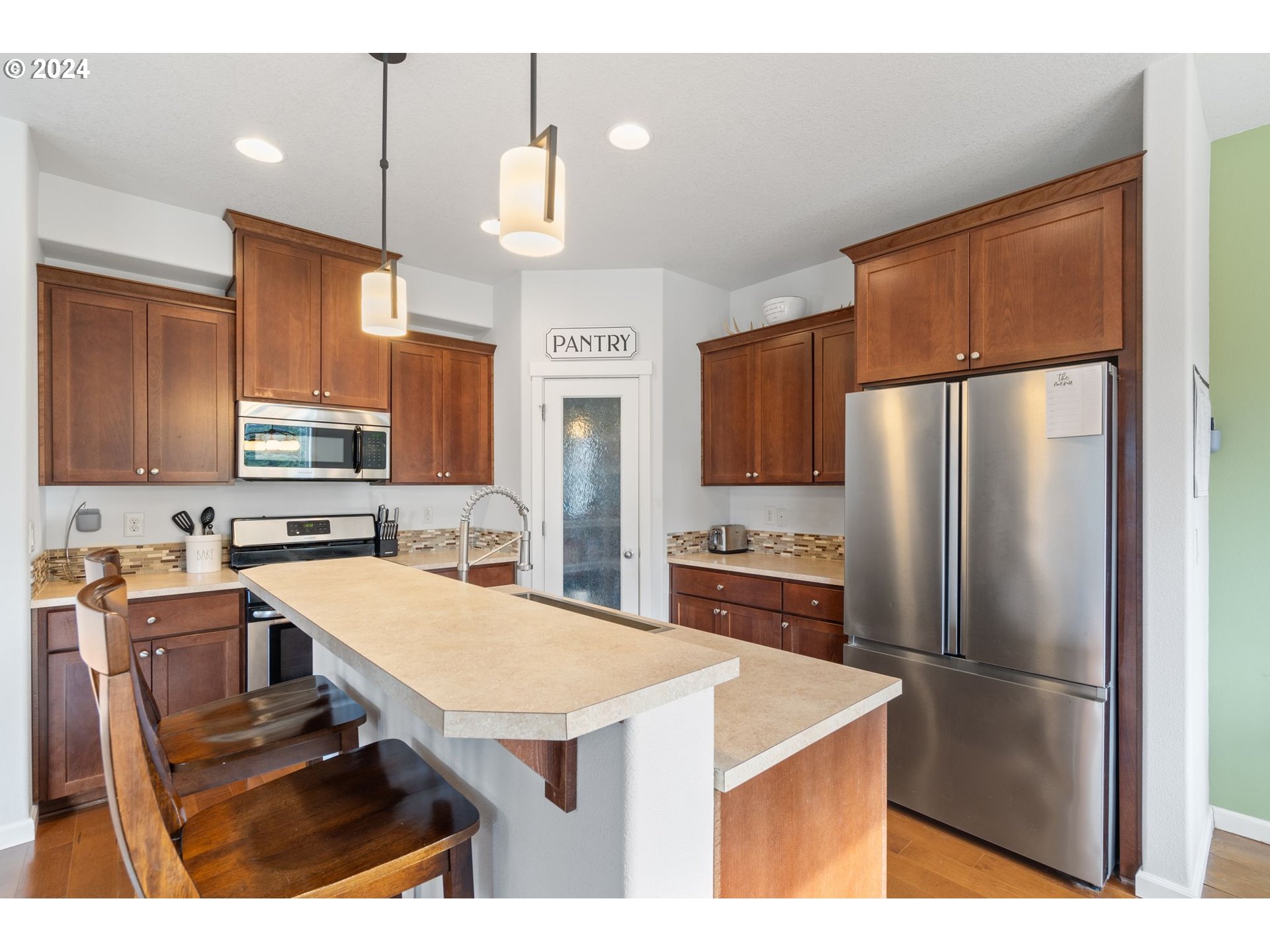 3519 North 6th Circle Ridgefield, WA 98642 - Photo 8 of 40 a kitchen with a refrigerator a sink a stove and chairs