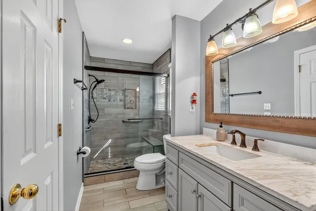a bathroom with a granite countertop sink toilet and shower