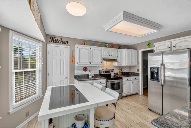 a kitchen with a refrigerator a stove top oven and a sink