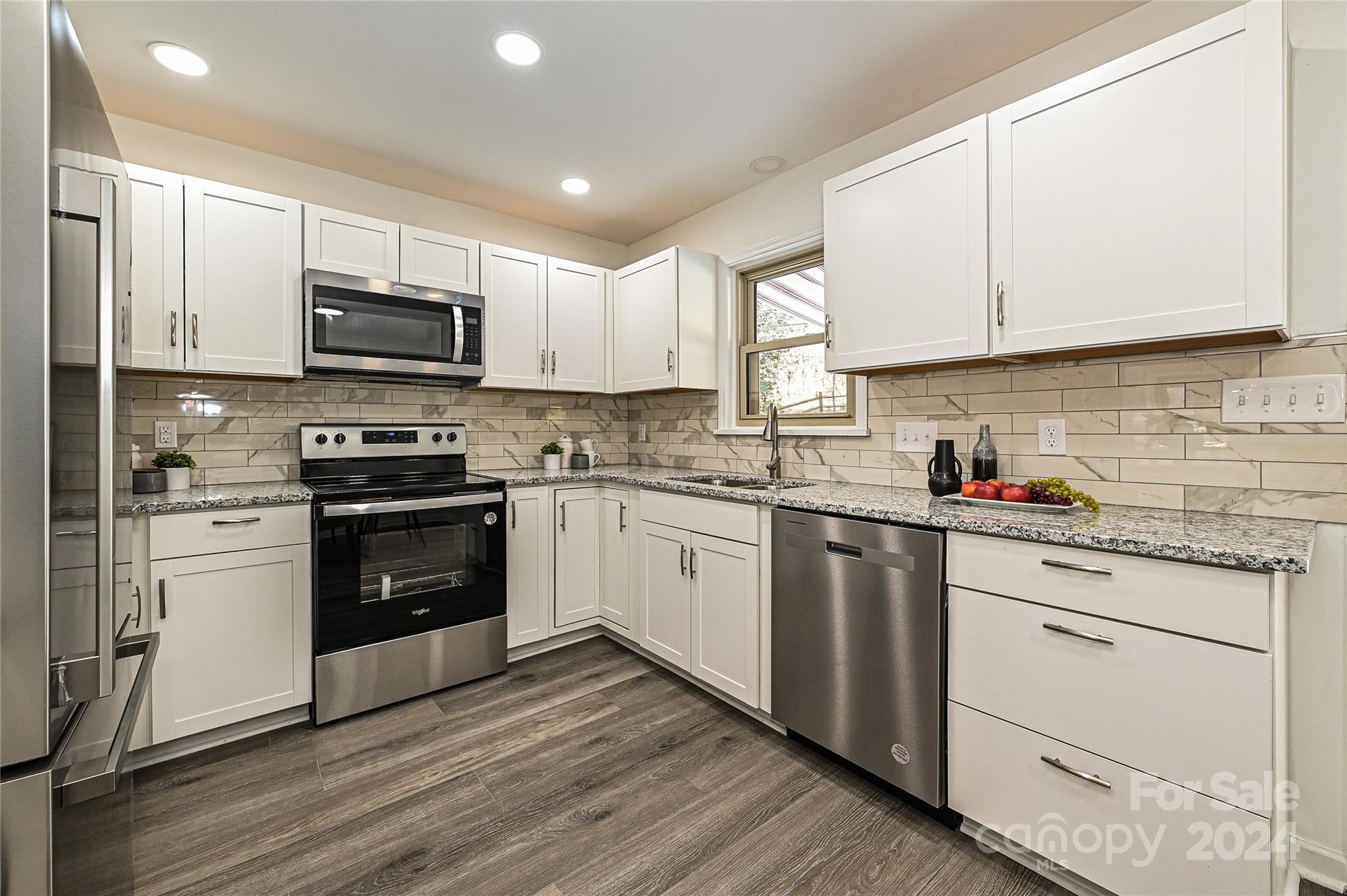 8617 Pine Circle Charlotte, NC 28215 - Photo 8 of 30 a kitchen with stainless steel appliances granite countertop white cabinets a sink a stove a microwave and cabinetry