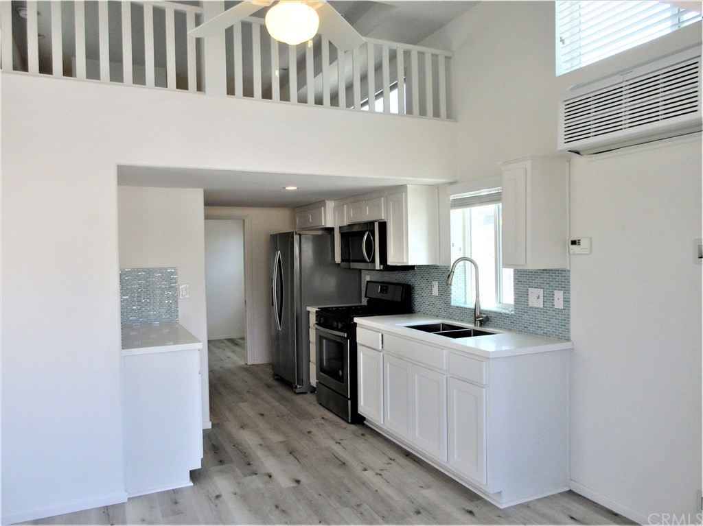 102 Sandy Drive San Clemente, CA 92672 - Photo 3 of 16 a kitchen with stainless steel appliances granite countertop a stove a sink and a refrigerator